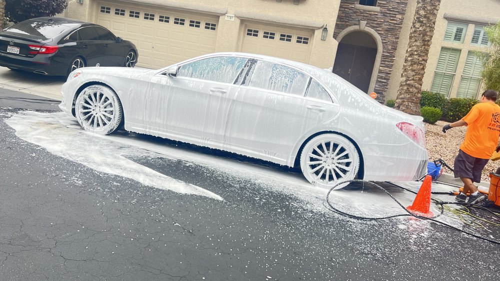 A white Mercedes covered in thick snow foam during a 3 In One mobile detail in Las Vegas